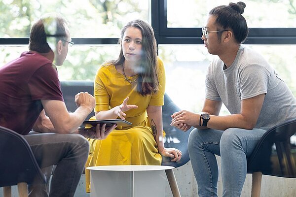 Drei Personen bei einem Meeting in einer modernen Lounge 